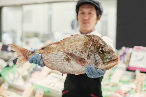 Young man working in the fish department.