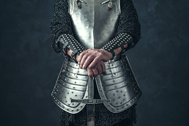 istock Weathered hands of knight holding sword. 542564590