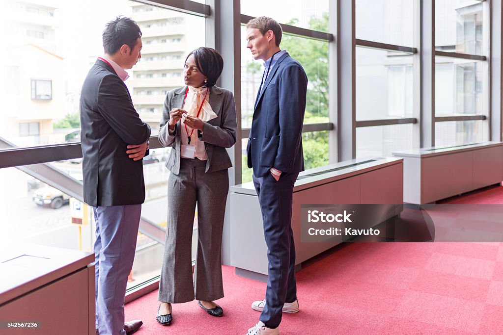 International hommes et femmes d'affaires parlons de couloir d'immeuble de bureaux - Photo de Traduction libre de droits