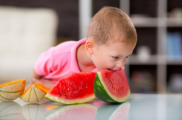 istock Happy cute little boy eating watermelon 542569116