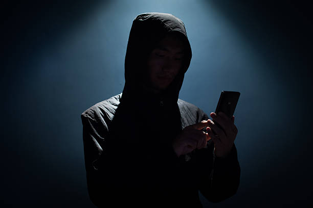 Hacker holding phone stock photo