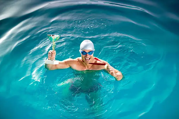 Photo of Happy swimmer with goblet and medal