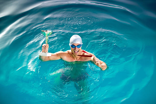 happy swimmer with goblet and medal - blue water swimming pool sports and fitness imagens e fotografias de stock