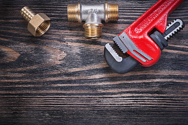 istock Monkey wrench brass equal tee hose nipple on wooden background 542580090