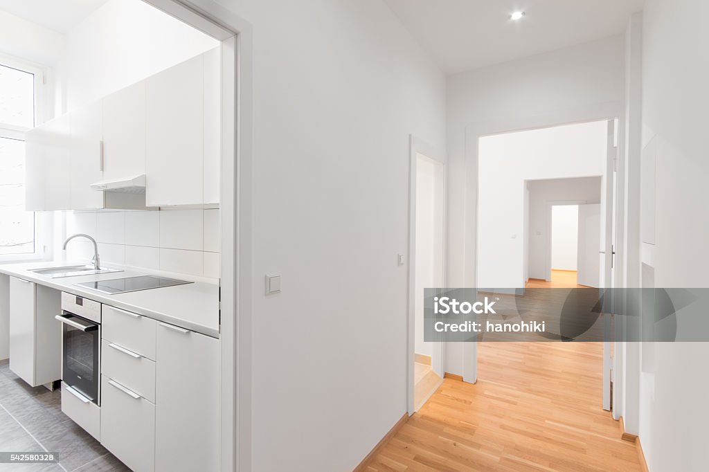 leere Wohnung, weiße Küche und Holzboden - Lizenzfrei Wohnung Stock-Foto