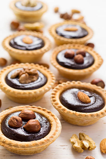 istock Nutty chocolate dessert small tarts on a white background 542581904
