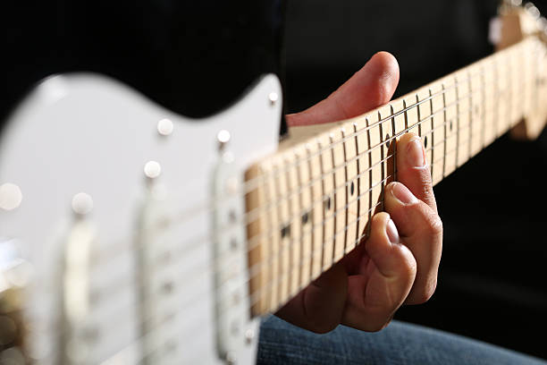 istock Male hands playing electric guitar on maple fretboard 542582010