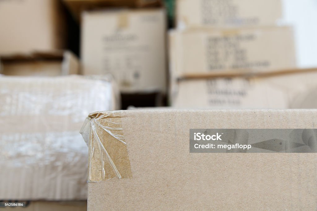 Pile of brown cardboard boxes at warehouse of market Pile of brown old used cardboard boxes at warehouse of market. Different stuff packed in set of carton boxes ready for delivery, ship insurance, logistics business, garbage utilization concept Beige Stock Photo