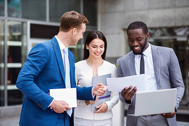 istock Pleasant cheerful colleagues standing near office building 542586388