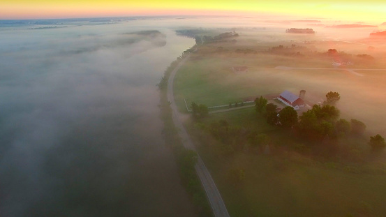 Mystical foggy country landscape with river, farms and homes,aerial view.