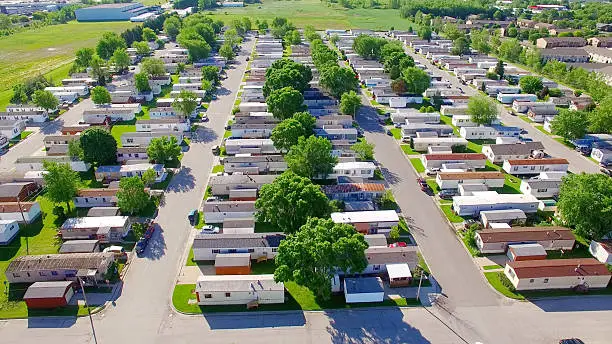 Vast trailer park, mobile home court on sunny summer morning, aerial view.
