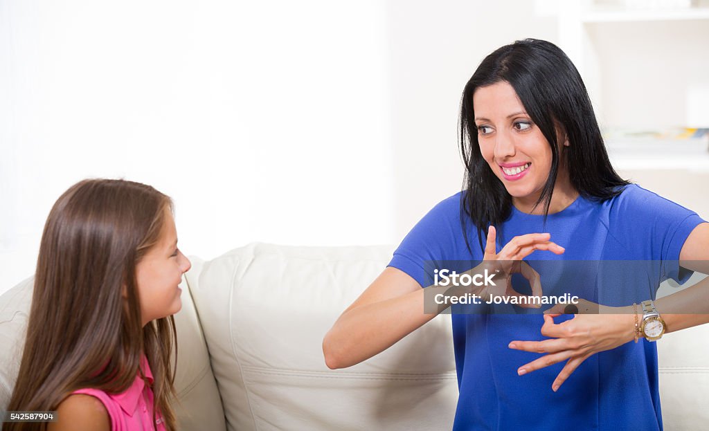 Smiling deaf girl learning sign language Sign Language Stock Photo