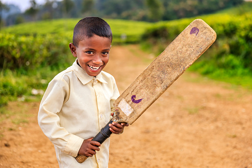 Sri Lankan little boy playing cricket on a tea plantation near Nuwara Elliya, Sri Lanka. Sri Lanka (Ceylon) is the world's fourth largest producer of tea and the industry is one of the country's main sources of foreign exchange and a significant source of income for laborers.http://bhphoto.pl/IS/rajasthan_380.jpg