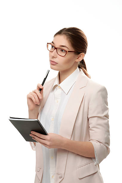 istock Young stylish woman standing holding a notepad and  pen. 542592908
