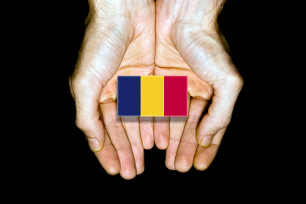Flag of Chad in hands isolated on black background.