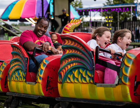Anderson, California, USA- June 17, 2016: County fair goers enjoying a ride in the shape of a dragon at the Shasta County Fair in northern California.