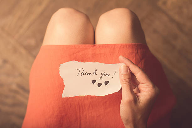 istock Woman holding a thank you note in her hand 542689092