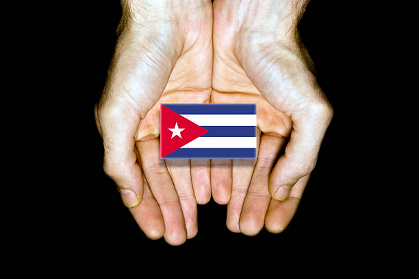 Flag of Cuba in hands isolated on black background.