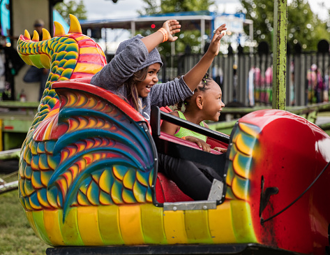 Anderson, California, USA- June 17, 2016: County fair goers enjoying a ride in the shape of a dragon at the Shasta County Fair in northern California.