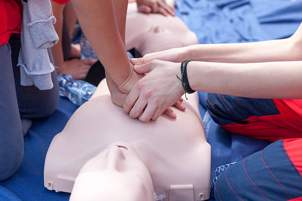 First aid training Cardiopulmonary resuscitation (CPR) being performed on a medical-training manikin first aid class stock pictures, royalty-free photos & images
