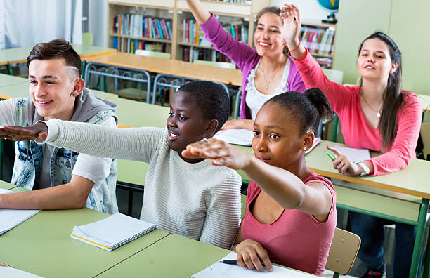 istock Group of happy school pupils  raise their hands up 542692396