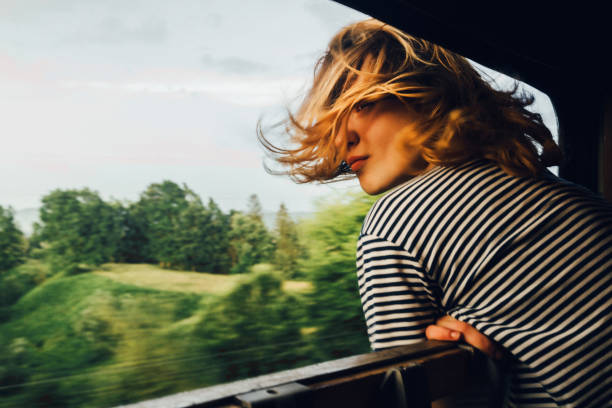 woman looking at the view from train - 金色頭髮 圖片 個照片及圖片檔