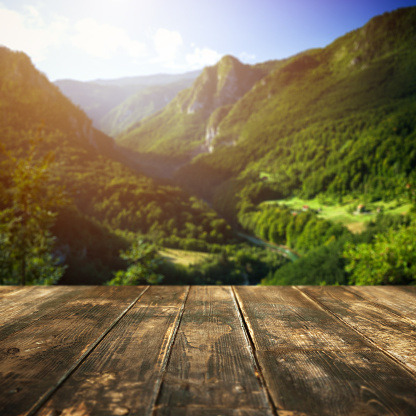 Old brown wooden planks on foreground, beautiful defocused mountain landscape on background. Aerial view.