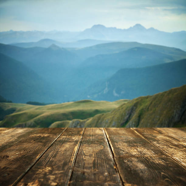 istock Wooden floor and defocused dramatic landscape on background 542692954
