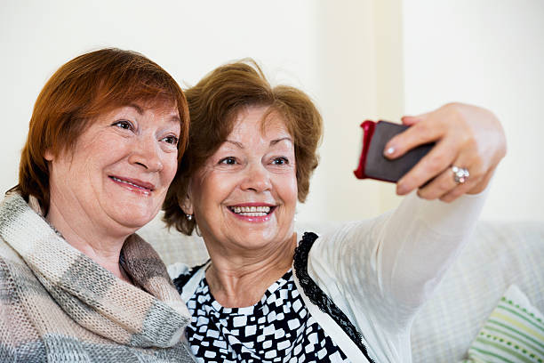 istock Modern smiling mature women using mobile phone 542693566