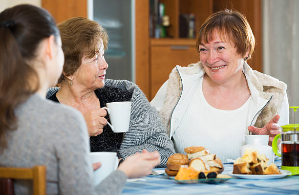 istock Senior women talking with girl while tea drinking 542693960