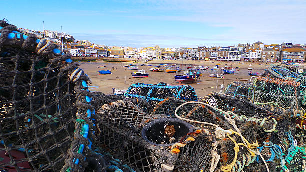 istock Lobster pots stacked up in St Ives, Cornwall overlooking harbour 542694042
