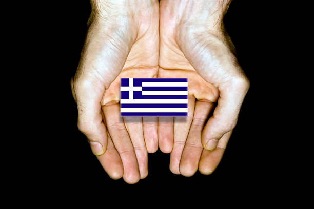 Flag of Greece in hands isolated on black background.