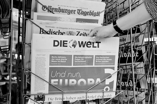 Strasbourg, France - June 25, 2016: Woman buying Die Welt newspaper with shocking headline titles at press kiosk about the Brexit referendum in United Kingdom requesting to quit the European Union