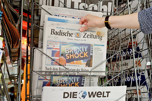 mulher comprar badische zeitung sobre brexit - newspaper headline finance recession anxiety imagens e fotografias de stock
