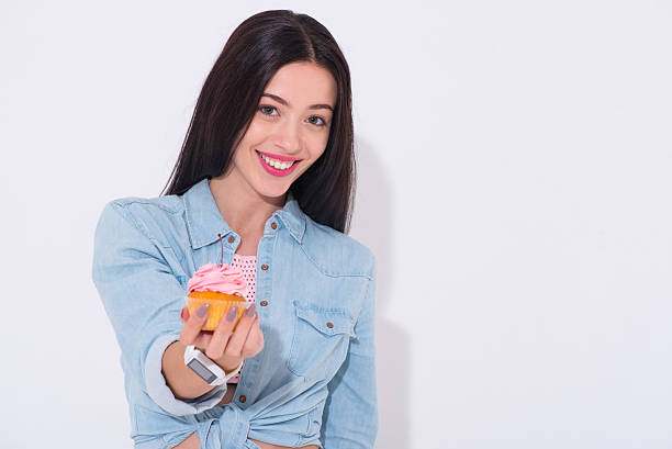 istock Overjoyed smiling woman holding cupcake 542698828