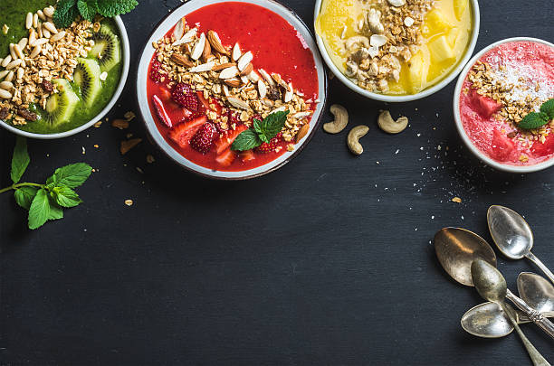 istock Healthy summer breakfast concept. Colorful fruit smoothie bowls with nuts 542698998