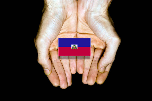 Flag of Haiti in hands isolated on black background.