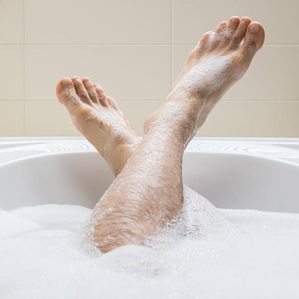 istock Men's feet in a bathtub, selective focus on toes 542712962