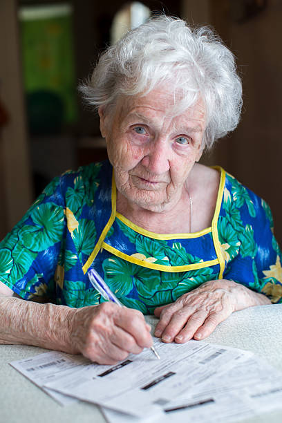 istock An elderly woman pays the utility bills. 542712970