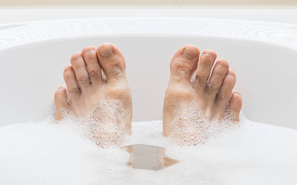 istock Men's feet in a bathtub, selective focus on toes 542712992