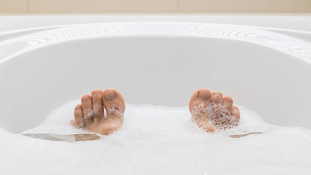 istock Men's feet in a bathtub, selective focus on toes 542713014