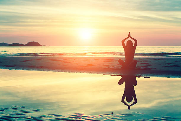 istock Silhouette young woman practicing yoga on the beach 542713240