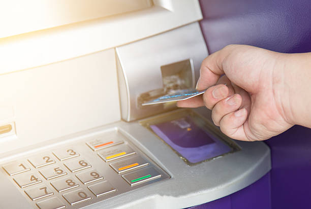 istock Hand inserting ATM credit card into bank machine 542713714