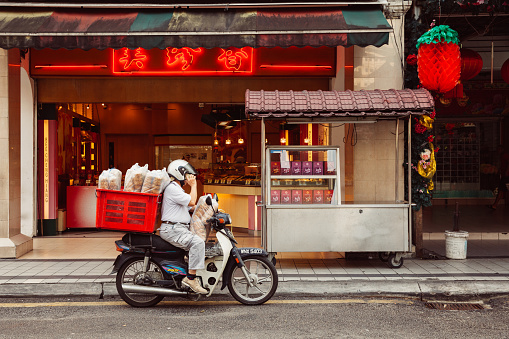 Kuala Lumpur, Malaysia - March 17, 2016:  Man delivering supplies to Chinese restaurant in Chinatown, Kuala Lumpur.