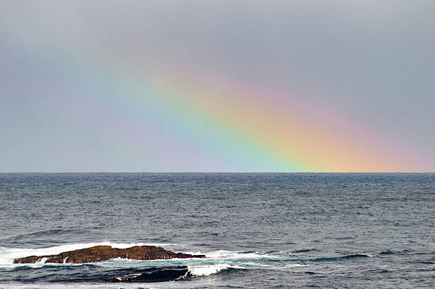 istock rainbow and stone in the ocean 542716592