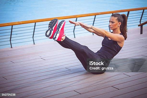 Young Female Athlete Performs Ab Crunches Outdoors Stock Photo - Download Image Now - Exercising, Relaxation Exercise, Abdominal Muscle