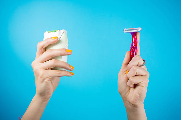 Red shaver and epilator in woman hands Red shaver and epilator in woman hand. Electric vs manual shave epilator stock pictures, royalty-free photos & images