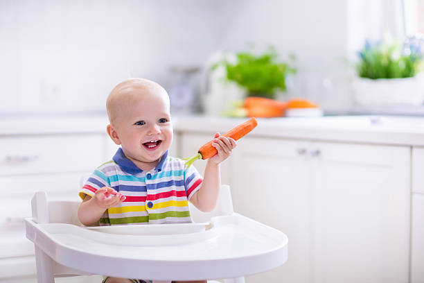 istock Little baby eating carrot 542726158