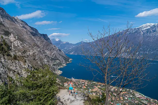 Woman with beautiful view on Limone sul Garda from the mountainside, Italy