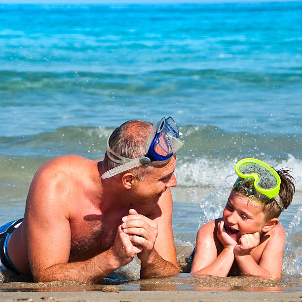 istock Father and little son on the beach with diving mask 542727214